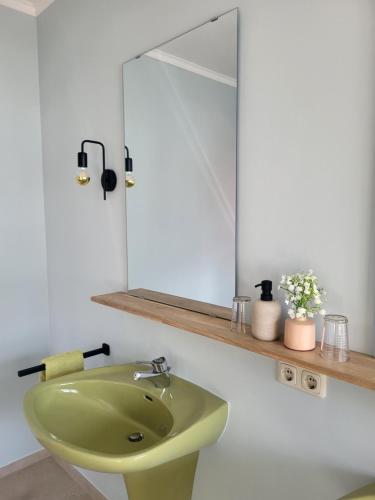 a bathroom with a green sink and a mirror at Pension Villa Bergkristall in Eschenlohe