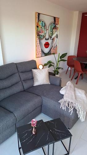 a living room with a gray couch and a painting at Casa Nina Novastar in San Pedro del Pinatar