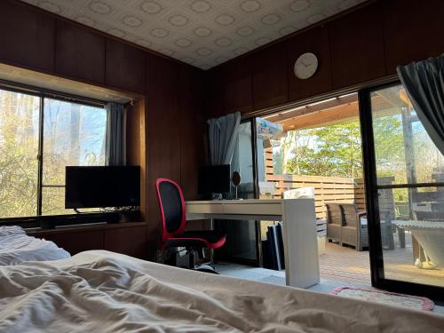 a bedroom with a bed and a desk with a computer at Ondolphin in Narusawa