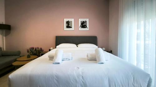 a bedroom with a white bed with towels on it at Gk Central Studio Xanthi in Xanthi