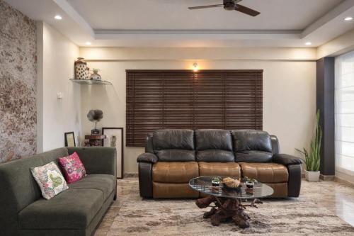 a living room with a couch and a table at Coffee Bean Inn in Bangalore