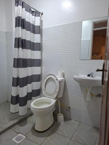 a bathroom with a toilet and a sink at Cynergy Home in Nairobi