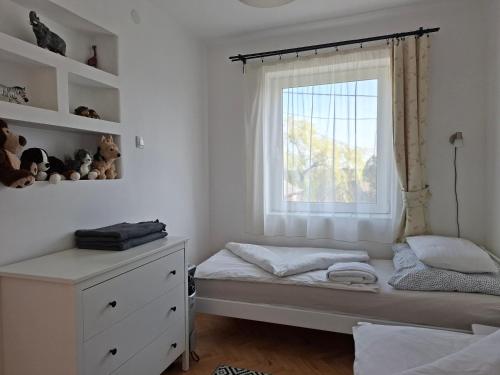 a small bedroom with a bed and a window at Corddora Apartman in Mezőkövesd
