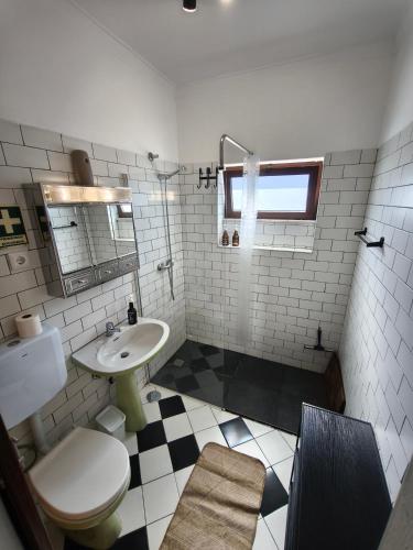 a bathroom with a white toilet and a sink at Casa das Flores in Santo Tirso
