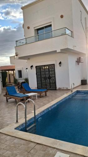 a house with a swimming pool in front of a house at villa baya midoun in Midoun