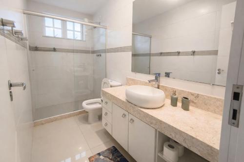 a white bathroom with a sink and a toilet at Casa Aconchegante com Vista pertinho do Centro Histórico in Petrópolis