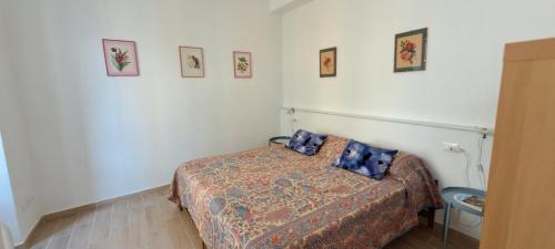 a small bedroom with a bed and pictures on the wall at Appartamento Mimma in Stresa