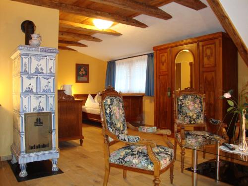 a living room with a chair and a bedroom at Historisches Genusshotel Löwen in Schopfheim