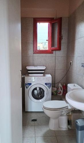 a bathroom with a washing machine and a toilet at Helios-Selene Villa in Lévktron