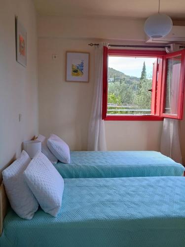 a bedroom with two beds and a window at Helios-Selene Villa in Lévktron