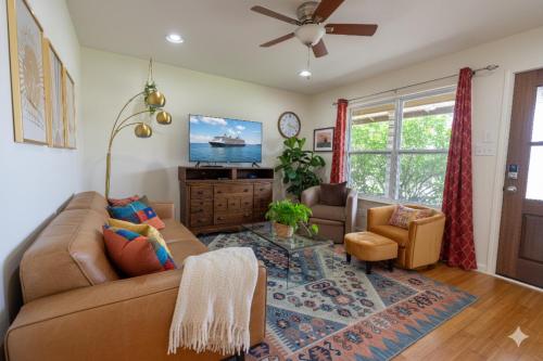 a living room with a couch and a tv at SoCo Greenery Home for Long Stays with Spacious Fenced Yard & Ameniites in Austin