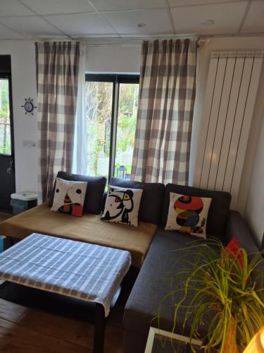 a living room with a couch and a table at Channel-Appartement cosy avec piscine, jardin & nature aux portes de Paris in Saint-Maurice
