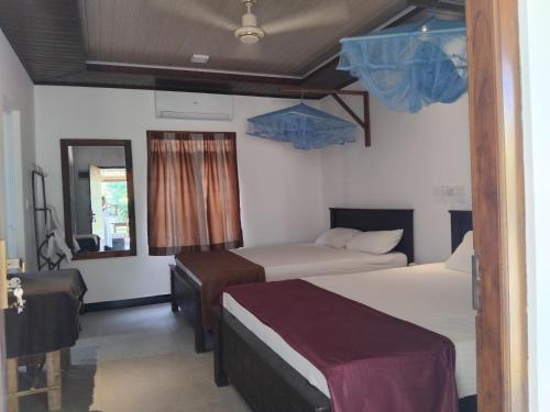 a hotel room with two beds and a mirror at Nesan’s villa in Trincomalee