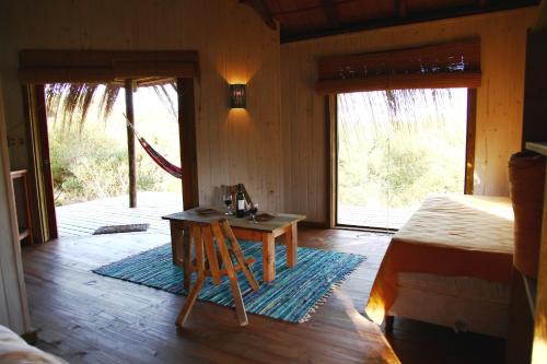 a room with a wooden table and a room with a door at Pueblo Barrancas in La Pedrera