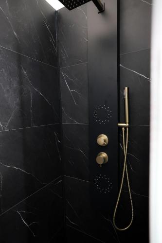 a black bathroom with a shower with black tiles at Le Quai Verrière in Belfort