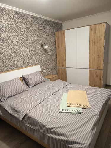 a bedroom with a bed with two towels on it at SweetHome in Ternopil