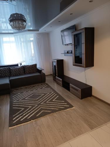 a living room with a couch and a television at SweetHome in Ternopil