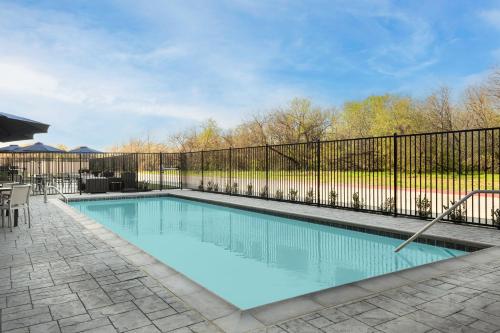 a swimming pool with a fence around it at Holiday Inn Express & Suites DFW Airport Southwest - Euless by IHG in Euless