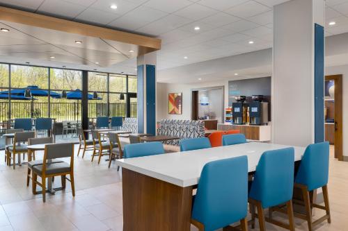 a dining area with blue chairs and tables at Holiday Inn Express & Suites DFW Airport Southwest - Euless by IHG in Euless