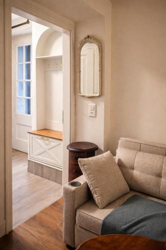 a living room with a couch and a mirror at The Old Coach Retreat in Rheinfelden