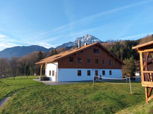 a large white barn with mountains in the background at Staufen-Chalet Hochreit in Anger