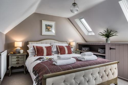 a bedroom with a bed with towels on it at Old Stable Cottage in Kingham