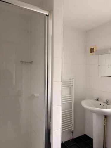 a white bathroom with a shower and a sink at Shipwright Inn in Pembroke Dock