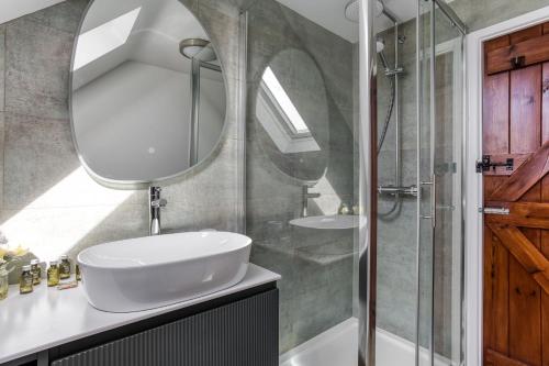a bathroom with a sink and a mirror at Old Stable Cottage in Kingham