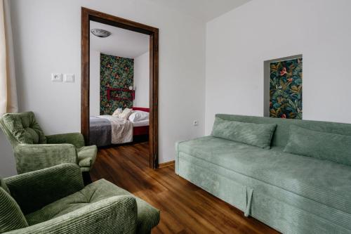 a living room with a couch and two chairs and a mirror at Familia in Český Krumlov