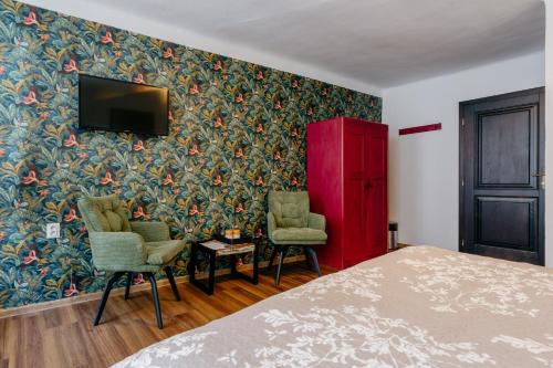 a bedroom with a bed and two chairs and a tv at Familia in Český Krumlov