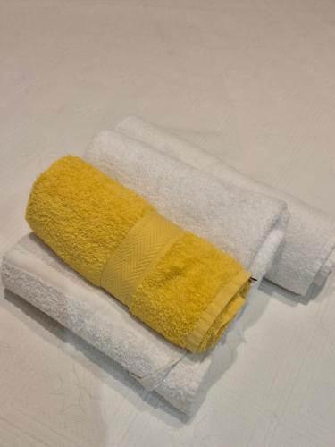 a yellow towel sitting on top of a white towel at Channel-Appartement cosy avec piscine, jardin & nature aux portes de Paris in Saint-Maurice