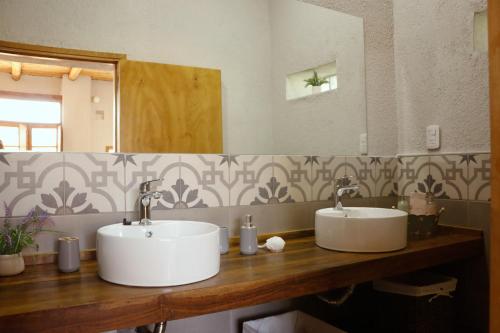 a bathroom with two sinks and a large mirror at El Rancho , casa de huéspedes in Tupungato
