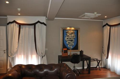a living room with a leather couch and a desk at Hotel 1908 in Forte dei Marmi