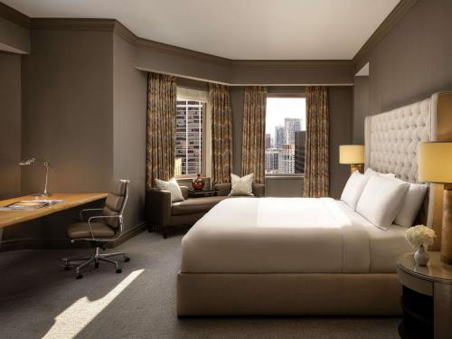 a hotel room with a bed and a desk and a window at Fairmont Chicago Millennium Park in Chicago