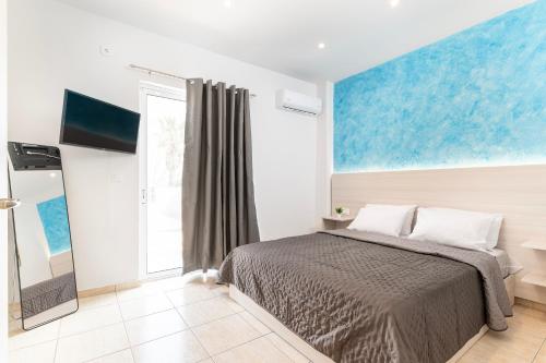 a bedroom with a bed and a painting on the wall at Azure Edge - Seafront View - Beach Stay in Tigaki