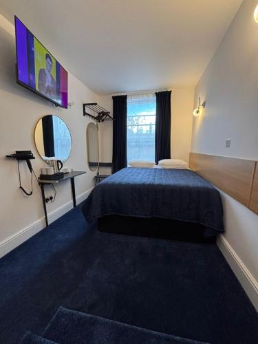 a hotel room with a bed and a mirror at Jubilee Hotel Kensington in London