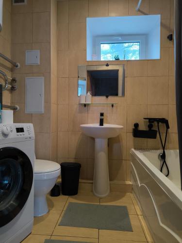 a bathroom with a sink and a washing machine at Apartment GLORIA in Narva-Jõesuu
