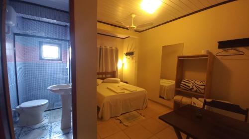 a small bathroom with a bed and a sink at Pousada Girar do Sol in Nova Friburgo
