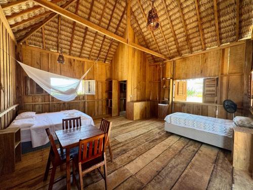 a bedroom with two beds and a table and chairs at Pousada Amor Do Arpoador in Tutóia