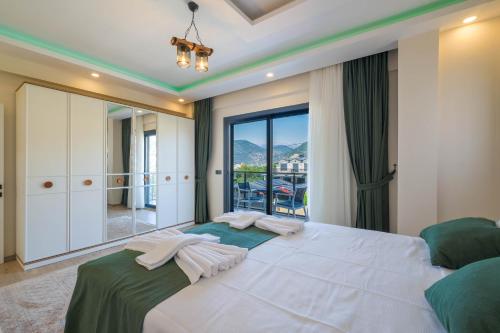 a bedroom with a large white bed and a large window at Villa Huzur in Fethiye