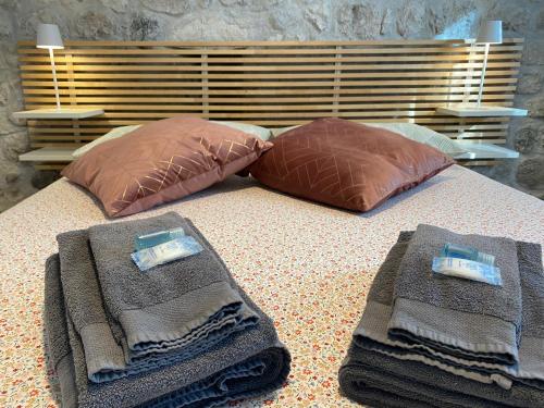 a bed with two pillows and towels on it at Appartamento Scaligeri in Venzone