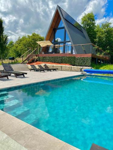 a house with a swimming pool and a building at Cabana Bradova Jacuzzi & Heated Pool A-Frame in Bîrsana