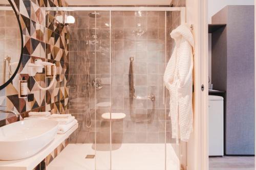 a bathroom with a shower and a toilet and a sink at Tuscany Hotel Alle Dune in Marina di Castagneto Carducci