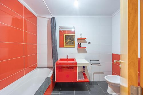 a bathroom with a tub and a sink and a toilet at T4 Espaçoso Perto da Praia e Aeroporto in Machico