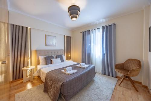 a hotel room with a bed and a chair at T4 Espaçoso Perto da Praia e Aeroporto in Machico