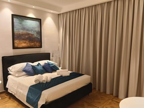a bedroom with a large bed with blue pillows at Suite Enea San Rocco in Sperlonga