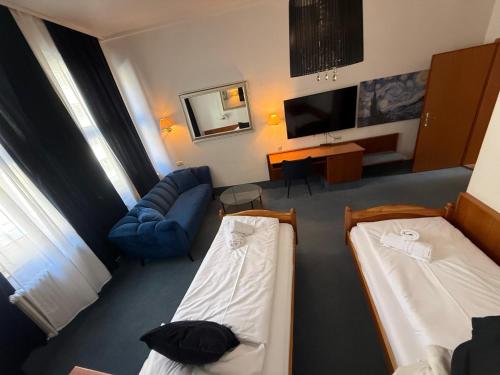 a hotel room with two beds and a couch at Luitpold Hotel in Nuremberg