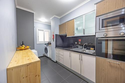 a kitchen with a wooden counter top in a room at T4 Espaçoso Perto da Praia e Aeroporto in Machico