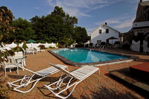 a swimming pool with chairs and a house at The Brandon Inn in Brandon