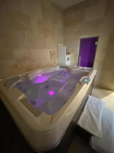 a bath tub with purple dye in a bathroom at Sweety Room in Chamalières